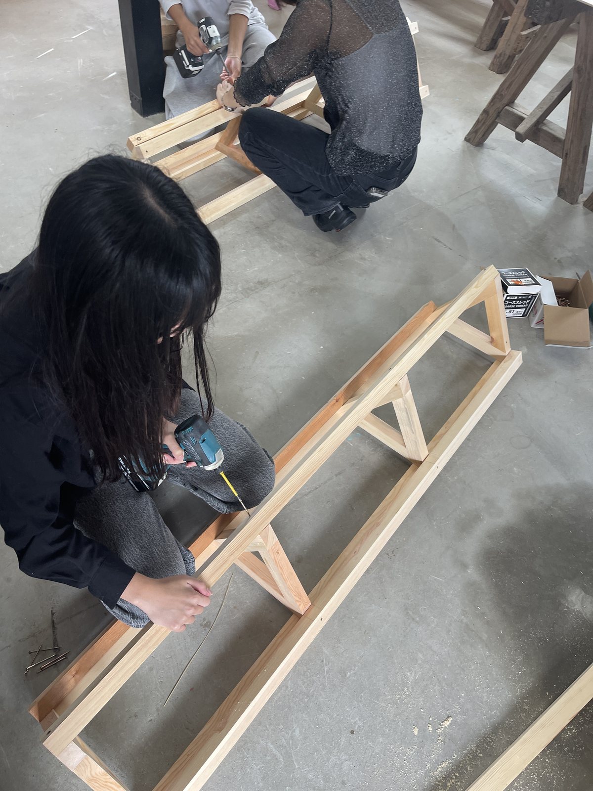 池田工務店さんの作業場で、ゲートの骨組みを組み立てる学生たち