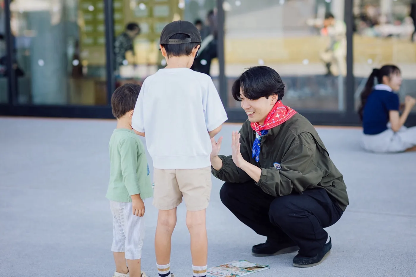 桑都の杜の広場で、子どもたちとハイタッチするメンバー