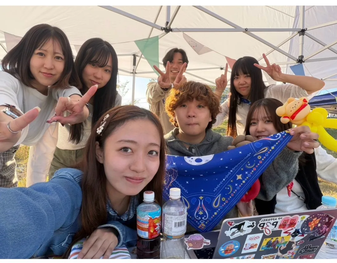 テントの下で集合写真を撮るメンバー